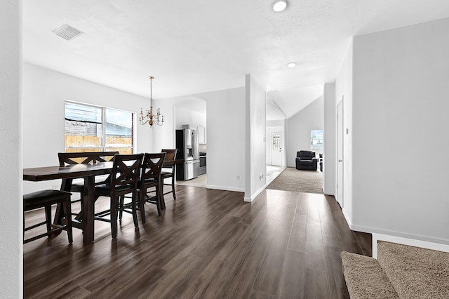 dining space featuring dark wood-type flooring, visible vents, a notable chandelier, and baseboards