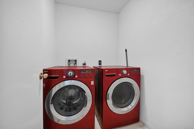 clothes washing area featuring baseboards, laundry area, and washer and dryer