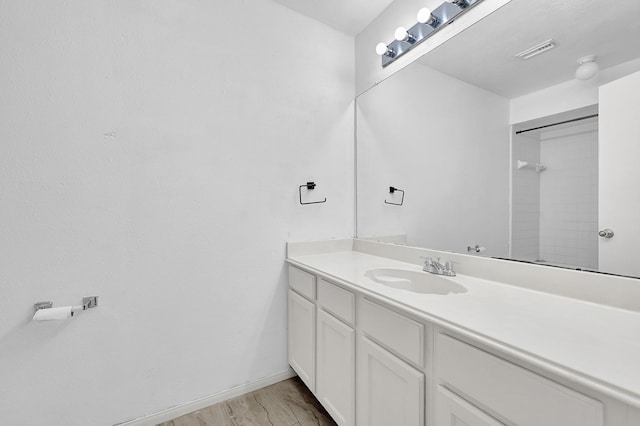 full bathroom featuring baseboards, visible vents, wood finished floors, and vanity