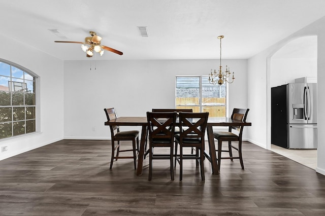 dining area with ceiling fan with notable chandelier, dark wood-style flooring, visible vents, and baseboards