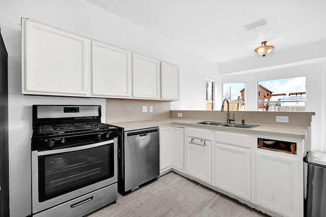 kitchen featuring appliances with stainless steel finishes, light countertops, and white cabinetry