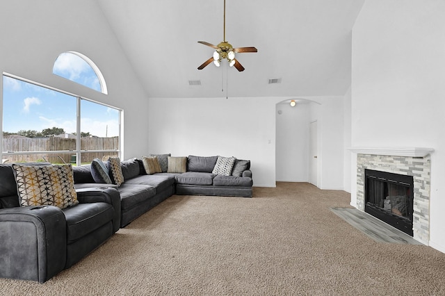 living room with a fireplace with flush hearth, visible vents, a ceiling fan, and light colored carpet