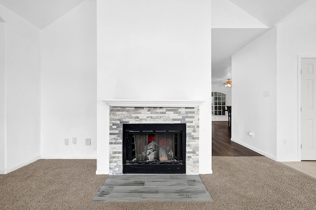 interior details featuring carpet floors, a fireplace, baseboards, and a ceiling fan