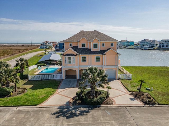 view of front of house featuring a garage, a water view, and a front yard