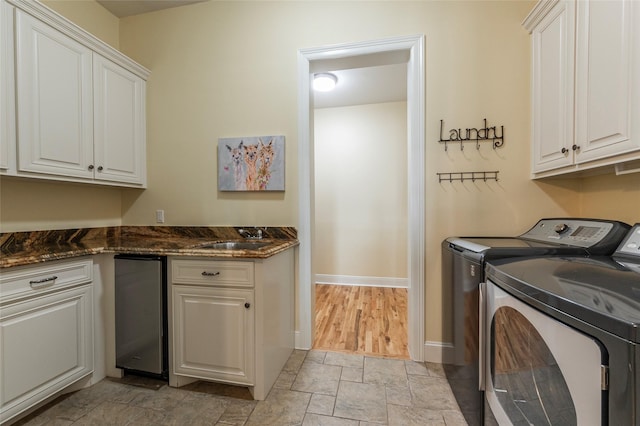 laundry room featuring washer and dryer, sink, and cabinets