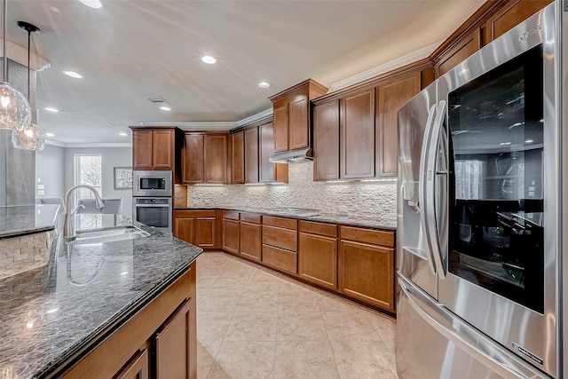 kitchen with appliances with stainless steel finishes, sink, decorative backsplash, hanging light fixtures, and dark stone counters