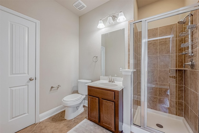 bathroom with tile patterned floors, toilet, a shower with shower door, and vanity