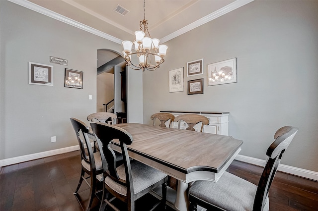 dining room featuring crown molding, dark hardwood / wood-style flooring, and a chandelier