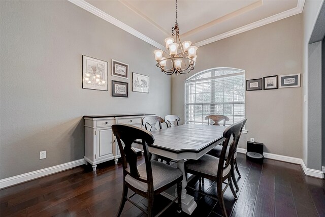 dining area featuring a raised ceiling, ornamental molding, dark wood-type flooring, and a notable chandelier