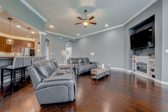 living room with dark wood-type flooring, ornamental molding, and ceiling fan