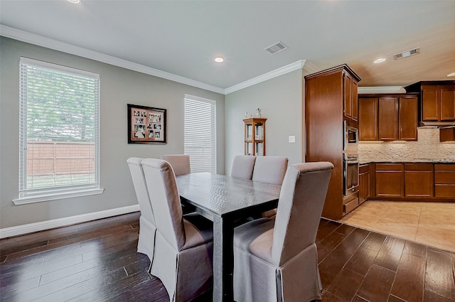 dining room with ornamental molding and dark hardwood / wood-style floors