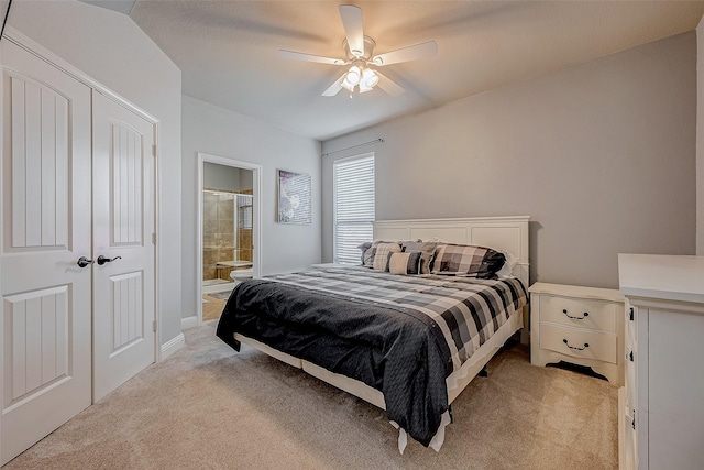 bedroom with light carpet, ensuite bath, and ceiling fan