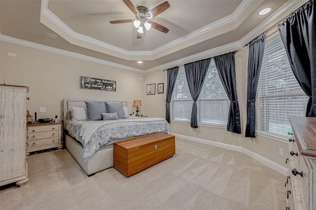 carpeted bedroom with a raised ceiling, ornamental molding, and ceiling fan