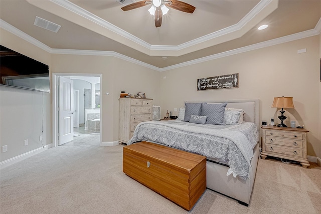 carpeted bedroom with crown molding, ensuite bathroom, ceiling fan, and a tray ceiling