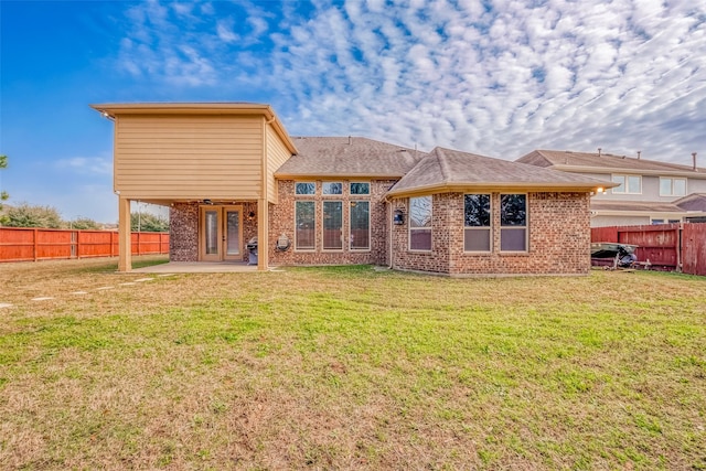 back of property with a patio and a yard