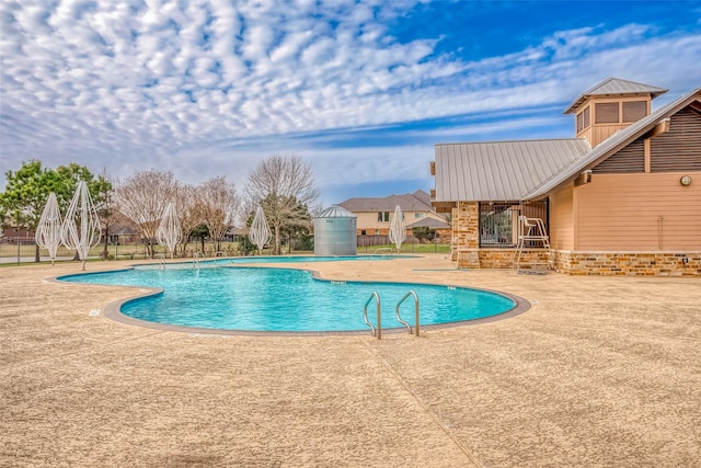 view of swimming pool with pool water feature and a patio