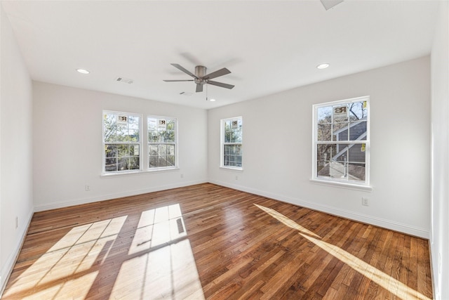 spare room featuring recessed lighting, visible vents, a ceiling fan, wood finished floors, and baseboards