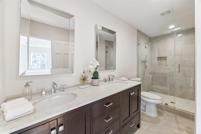 full bath featuring double vanity, visible vents, toilet, and a sink