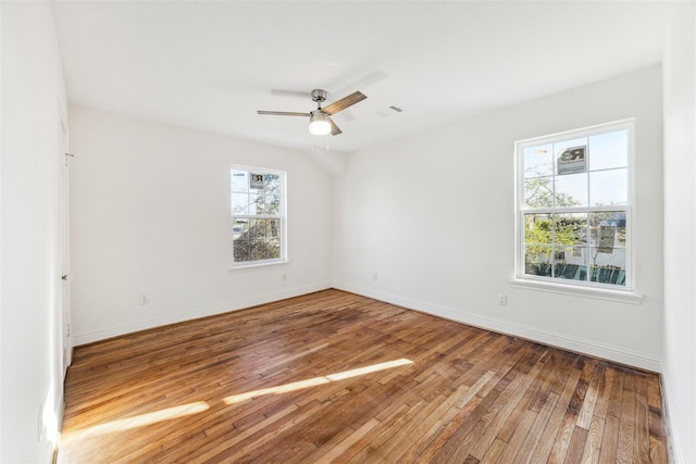 empty room with ceiling fan, baseboards, and wood finished floors