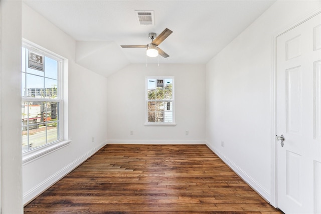 unfurnished room with baseboards, visible vents, ceiling fan, dark wood-type flooring, and vaulted ceiling