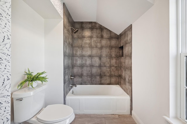 full bathroom featuring shower / bathtub combination, vaulted ceiling, toilet, and baseboards