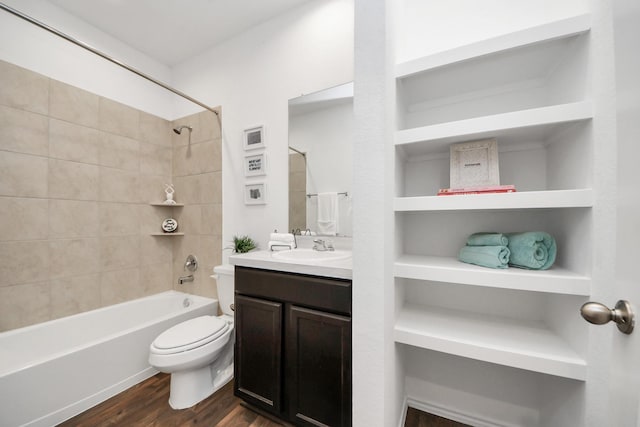 full bathroom featuring tiled shower / bath, vanity, toilet, and hardwood / wood-style floors