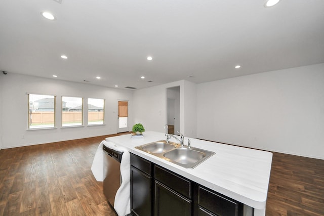 kitchen with dark hardwood / wood-style floors, stainless steel dishwasher, sink, and an island with sink