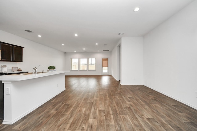 unfurnished living room with dark hardwood / wood-style flooring and sink