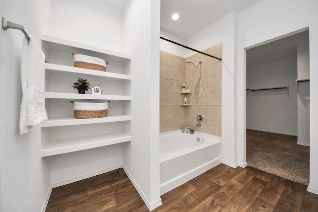 bathroom featuring wood-type flooring and tiled shower / bath