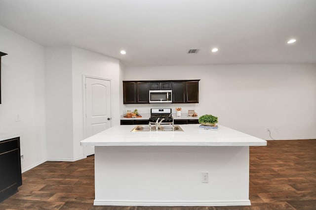 kitchen with appliances with stainless steel finishes, a kitchen island with sink, and sink