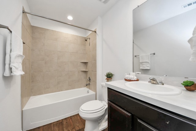 full bathroom with hardwood / wood-style flooring, vanity, toilet, and tiled shower / bath combo