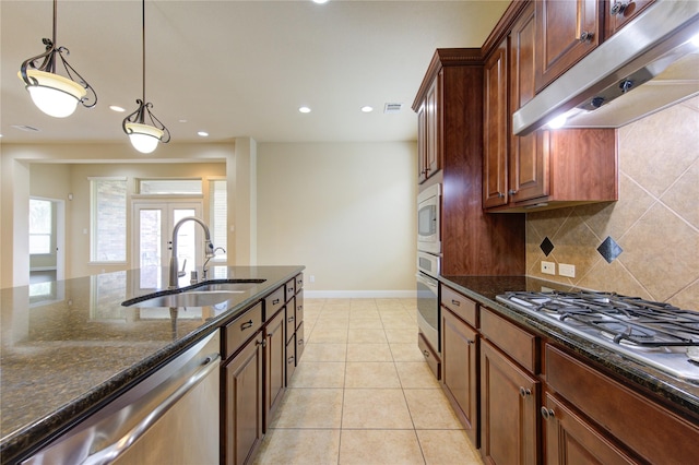 kitchen with sink, appliances with stainless steel finishes, backsplash, light tile patterned flooring, and dark stone counters