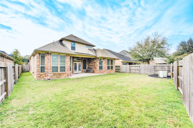 rear view of property with a patio and a yard