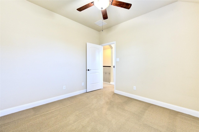 empty room featuring vaulted ceiling, light colored carpet, and ceiling fan