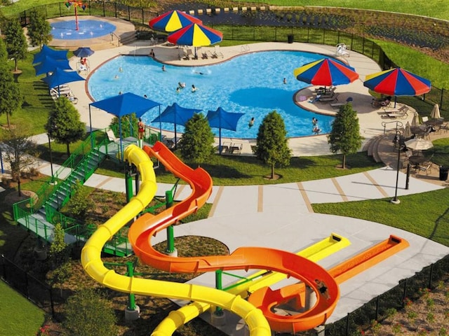 view of play area with a community pool, a yard, and a patio area