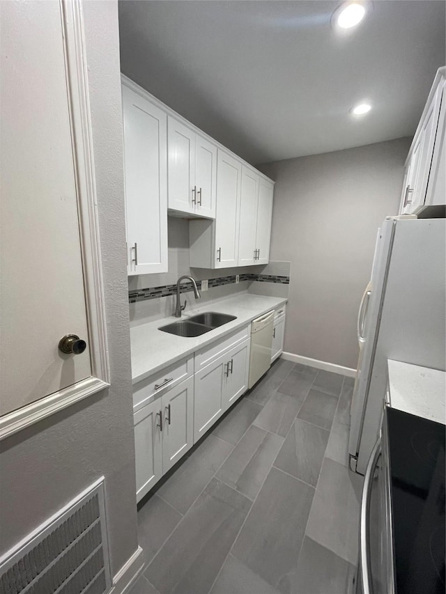 kitchen featuring sink, white cabinets, and white appliances