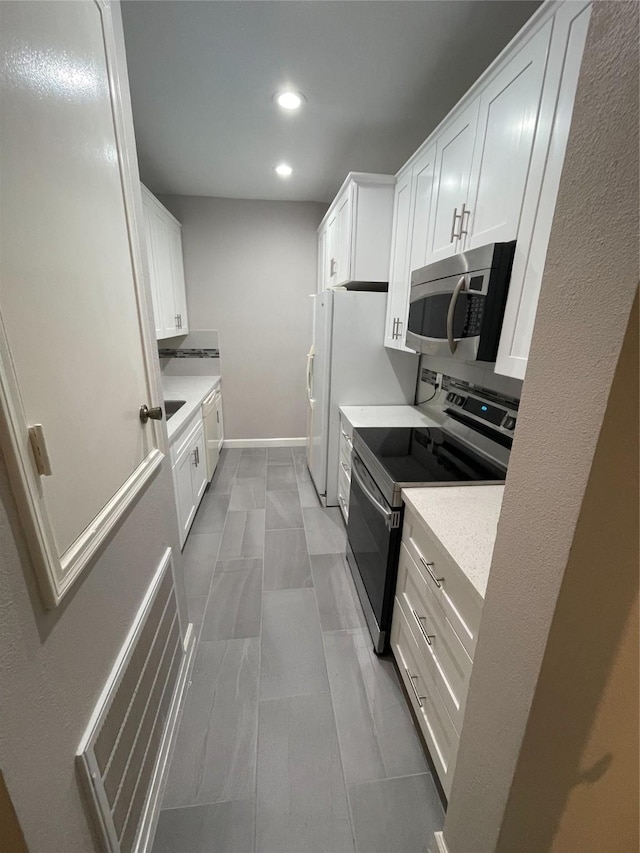 kitchen featuring stainless steel appliances and white cabinets