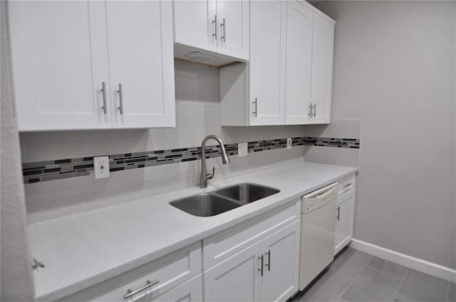 kitchen featuring sink, light tile patterned floors, dishwasher, white cabinets, and backsplash