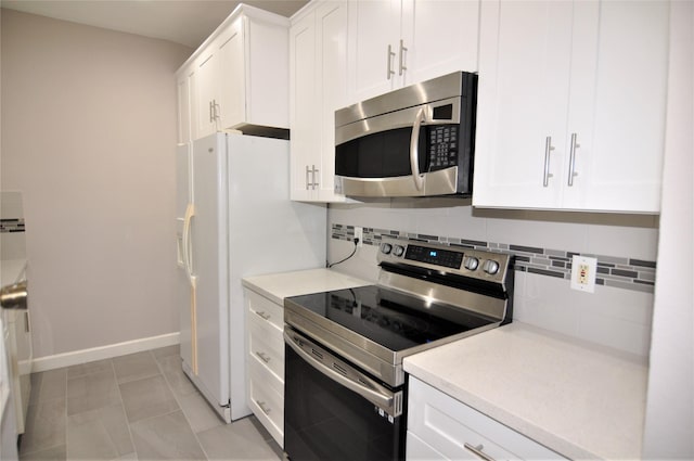 kitchen featuring white cabinetry, appliances with stainless steel finishes, light tile patterned flooring, and tasteful backsplash