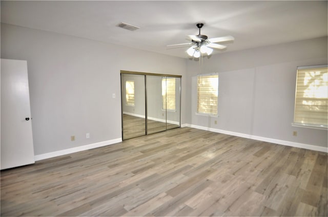 unfurnished bedroom featuring ceiling fan, a closet, and light hardwood / wood-style flooring