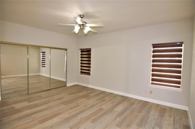 unfurnished bedroom with hardwood / wood-style flooring, ceiling fan, and a closet