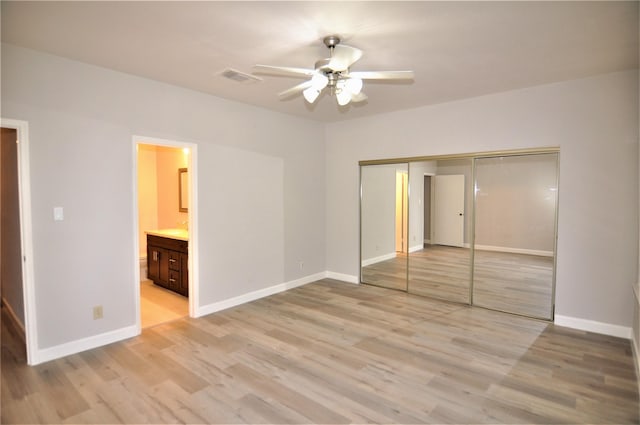 unfurnished bedroom with ceiling fan, a closet, connected bathroom, and light hardwood / wood-style flooring