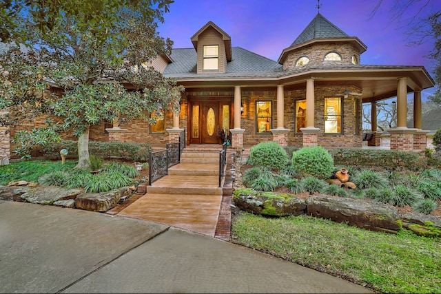 view of front facade with covered porch and brick siding