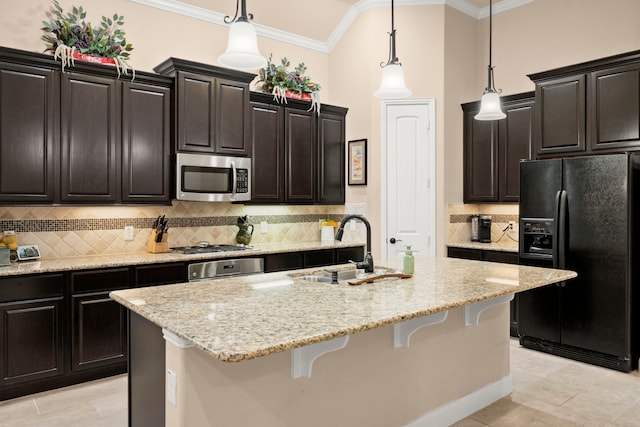 kitchen with crown molding, appliances with stainless steel finishes, a sink, an island with sink, and a kitchen bar