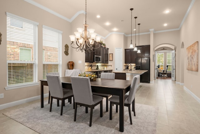 dining area featuring arched walkways, light tile patterned floors, recessed lighting, baseboards, and crown molding