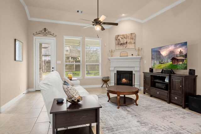 living room with lofted ceiling, visible vents, baseboards, a glass covered fireplace, and crown molding