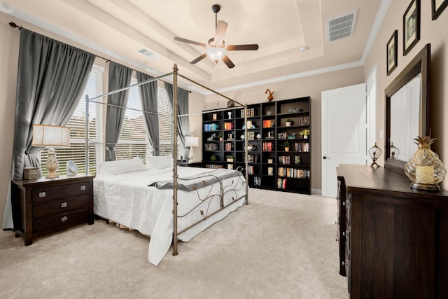 carpeted bedroom featuring visible vents, a raised ceiling, a ceiling fan, and ornamental molding