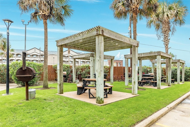 view of community featuring a yard, fence, and a pergola