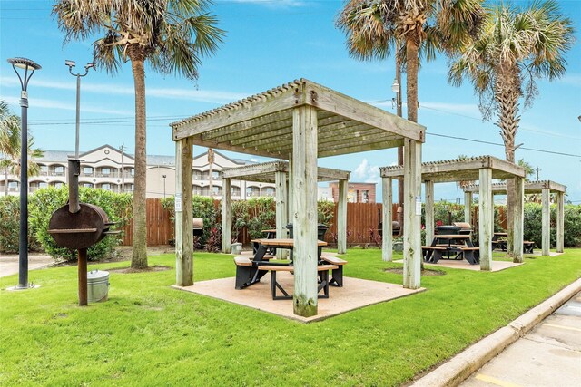 6102 Seawall Blvd Unit 128, Galveston, TX 77551 - surrounding community with a pergola, fence, and a lawn