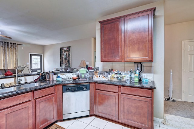 kitchen with light tile patterned flooring, sink, dark stone countertops, dishwasher, and backsplash